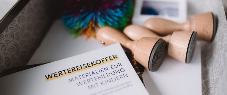 Der Inhalt des Wertereisekoffers: ein Wuschel, Infokarten, Stempel und Zettel.