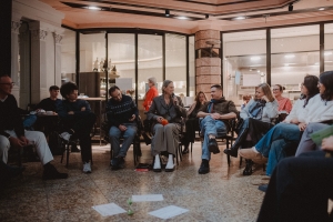 Ein Stuhlkreis mit Menschen, die miteinander ein philosophisches Gespräch führen.