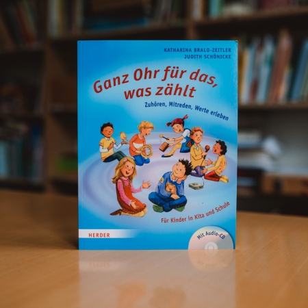 Das Buch "Ganz Ohr für das, was zählt" steht vor einem Bücherregal.